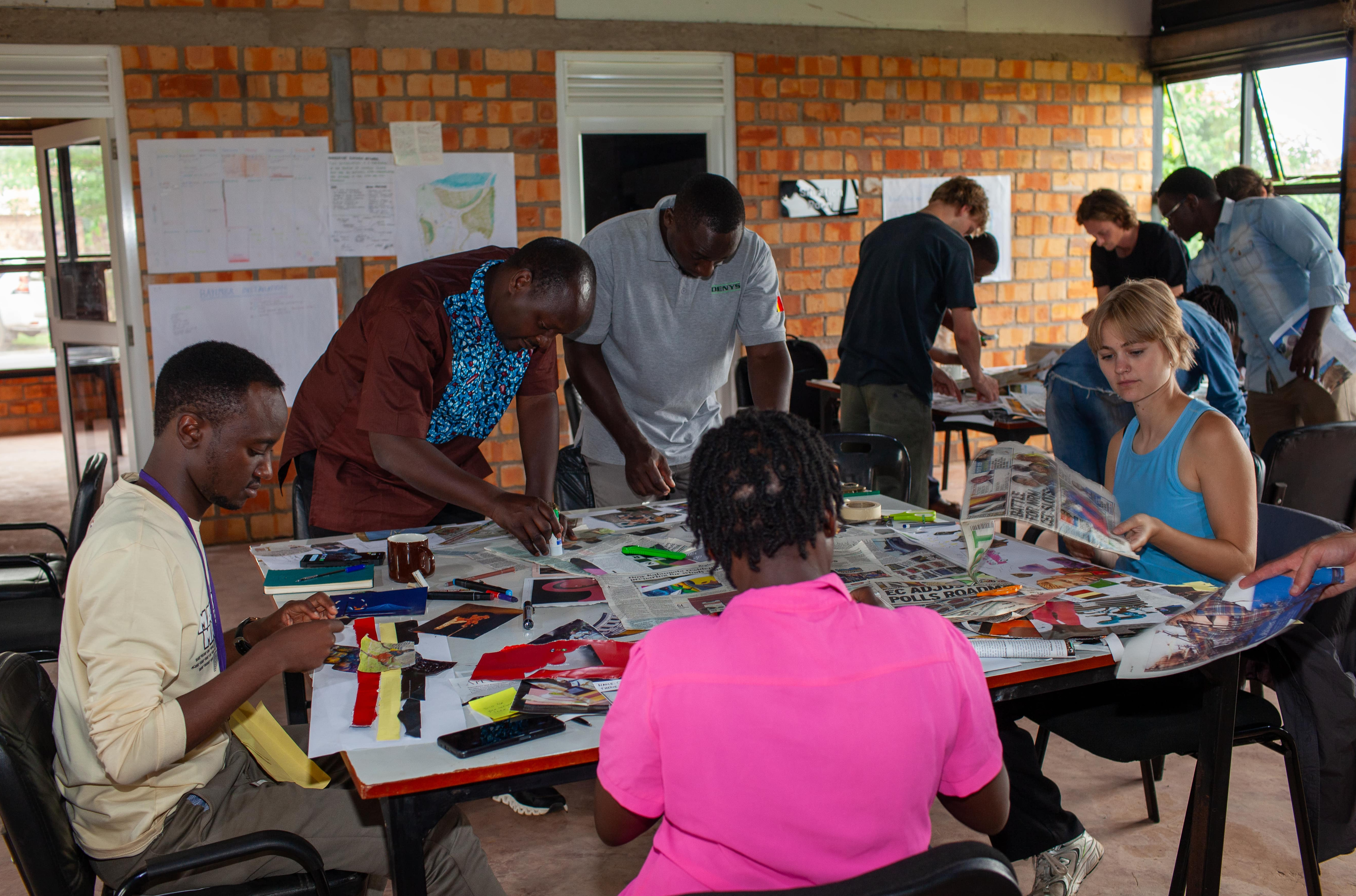 Team members collaborate closely, sorting through local fabrics and prints for their project.